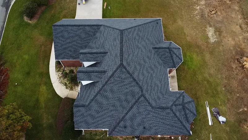 Overhead drone view of a completed shingle roof showing clean ridge lines and valleys