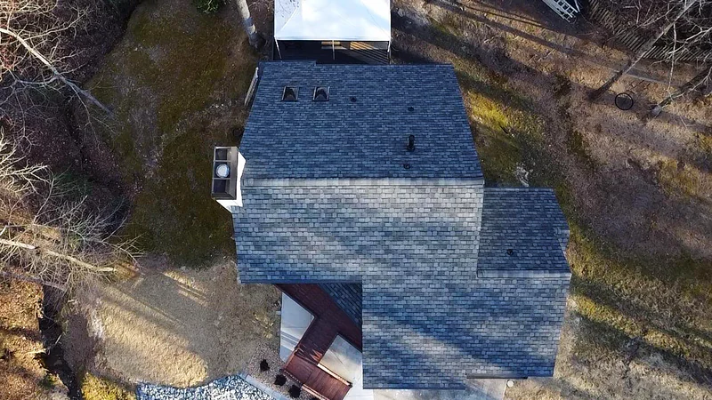 Close overhead drone shot of new shingles and ridge ventilation