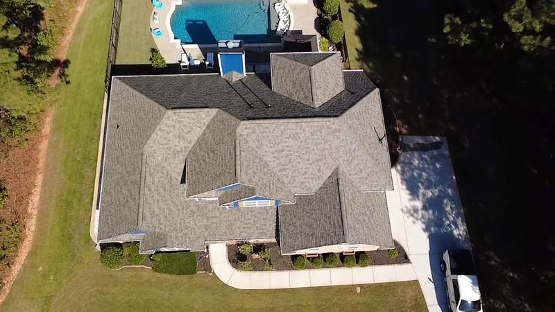 Aerial view of a home with a pool and a newly installed roof by GSP Exterior Works
