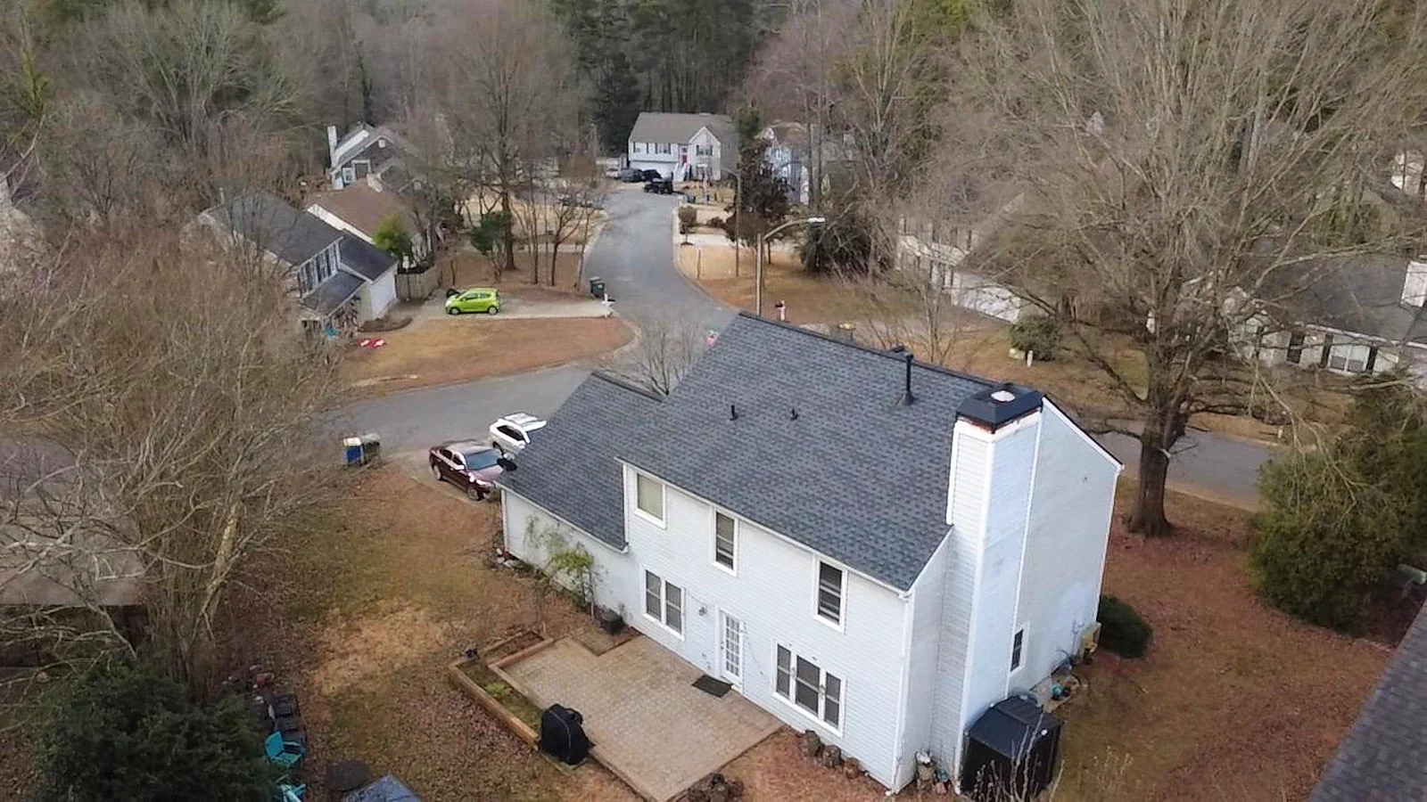 White colonial home photographed from the air after roof and gutter work